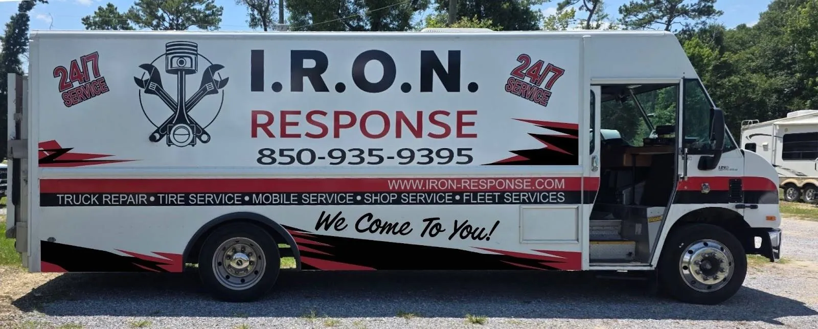 White I.R.O.N. Response step van with red and black graphics and its side door open, parked on gravel